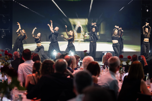**Alt-Tag für das zweite Bild:**  `Tänzer:innen in schwarzen Kostümen bei einer choreografierten Tanzshow auf der Eventbühne`